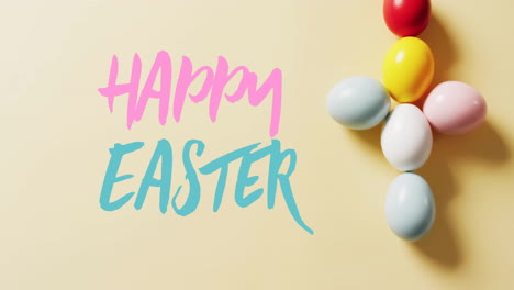 Animation-of-happy-easter-text-over-colourful-easter-eggs-on-yellow-background