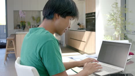 Adolescente-Asiático-Centrado-En-Su-Computadora-Portátil-En-Casa