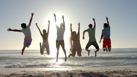 Diverse-group-of-friends-jump-in-joy-on-a-sunny-beach