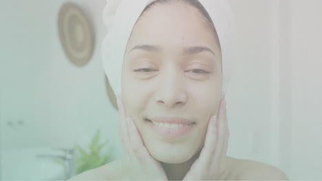 Animation-of-ripples-in-water-over-portrait-of-happy-biracial-woman-wearing-towel-in-bathroom