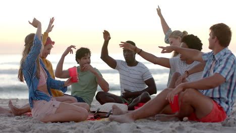 Diverse-friends-enjoy-a-lively-game-on-the-beach-at-sunset