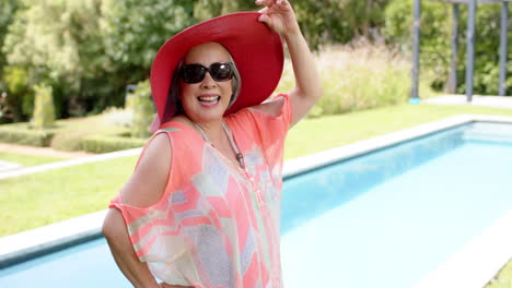 Senior-Asian-woman-enjoys-a-sunny-day-by-the-poolside