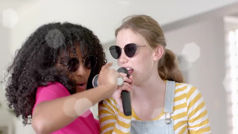 Animation-of-lights-over-happy-diverse-teenage-girls-with-sunglasses-and-microphones-singing-at-home