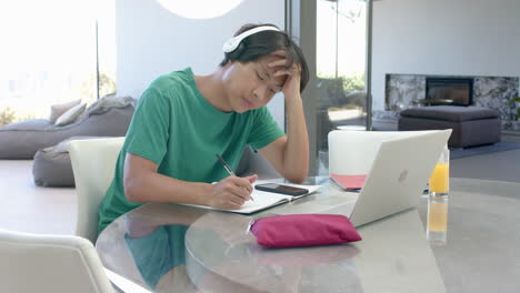 Asiatischer-Teenager-Lernt-Am-Laptop-In-Einem-Modernen-Zuhause
