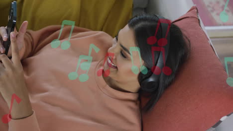 Animation-of-music-notes-over-biracial-woman-using-headphones-at-home