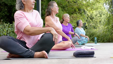 Diverse-group-of-women-practicing-yoga-outdoors,-focused-and-serene