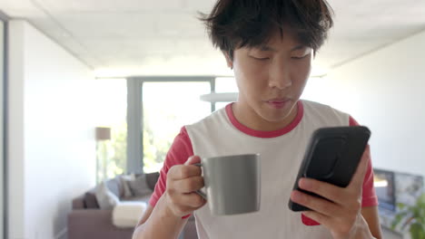 Teenage-Asian-boy-checks-his-phone-at-home