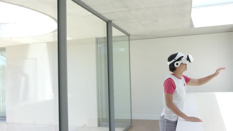 Teenage-Asian-boy-explores-virtual-reality-in-a-modern-home-setting-with-copy-space
