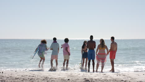 Diverse-group-of-friends-enjoy-a-day-at-the-beach,-with-copy-space