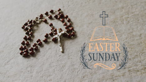 Animation-of-easter-sunday-text-over-rosary-on-grey-background