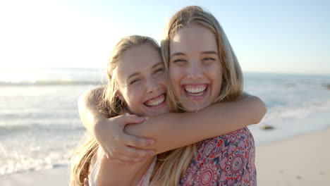 Two-young-Caucasian-women-embrace-joyfully-on-a-sunny-beach