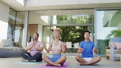 Young-biracial-women-and-Asian-man-meditate-at-home