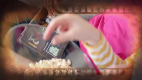 Animation-Eines-Filmbildes-über-Dem-Mittelteil-Verschiedener-Teenager-Mädchen,-Die-Zu-Hause-Ein-Tablet-Benutzen-Und-Popcorn-Essen
