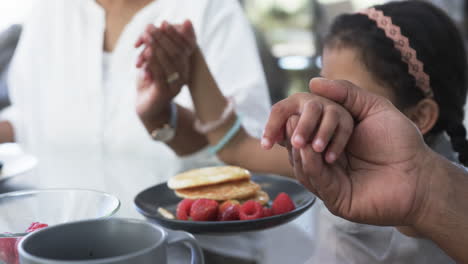 Biracial-woman-and-child-enjoy-breakfast,-the-woman-clapping