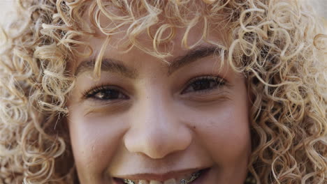 Close-up-of-a-young-biracial-woman-smiling-at-the-camera