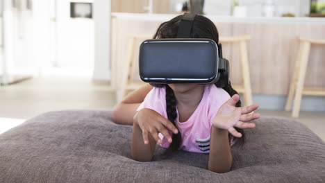Biracial-girl-with-a-VR-headset-experiences-virtual-reality,-hands-raised-defensively