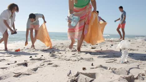 Diverse-volunteers-clean-up-a-beach,-with-copy-space