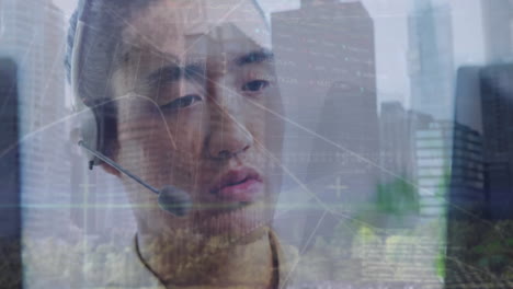 Animation-of-data-processing-and-cityscape-over-asian-businessman-using-phone-headset