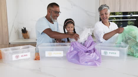 Biracial-family-sorts-recycling-materials-in-a-modern-kitchen