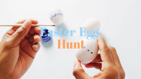 Animation-of-easter-egg-hunt-text-over-biracial-woman-painting-easter-eggs-on-white-background