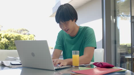 Adolescente-Asiático-Estudiando-En-Una-Computadora-Portátil-En-Casa