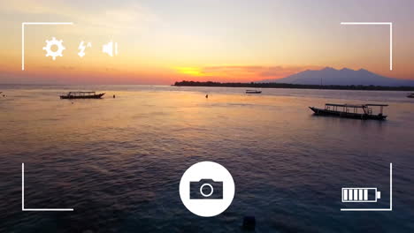 Animation-of-digital-camera-interface-screen-over-boats-on-ocean-at-sunset