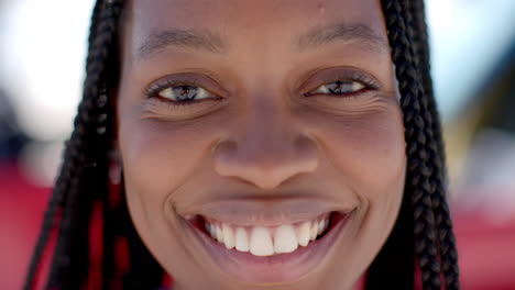 Close-up-of-a-young-African-American-woman-smiling-brightly-on-a-road-trip