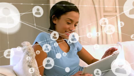 Animation-of-network-of-connections-with-people-icons-over-biracial-businesswoman-using-tablet