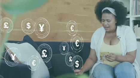 Animation-Von-Währungssymbolen-Und-Daten-über-Einer-Afroamerikanischen-Frau,-Die-Online-Mit-Karte-Bezahlt