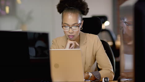 African-American-woman-focuses-intently-on-her-business-laptop-screen-at-the-office