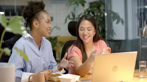 Young-African-American-woman-and-biracial-woman-collaborate-in-a-business-office-setting