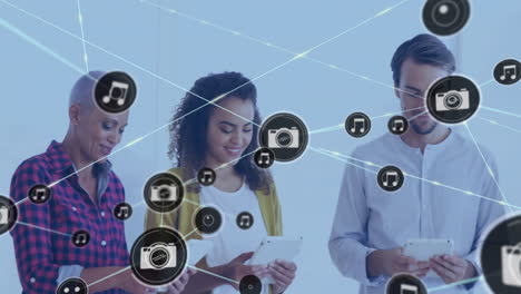 Animation-of-network-of-connections-with-camera-icons-over-diverse-business-people-with-tablets