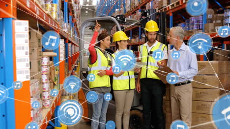 Animation-of-network-of-connections-with-icons-over-diverse-workers-discussing-in-warehouse