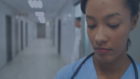 Animation-Von-Mediensymbolen-über-Einer-Gemischtrassigen-Krankenschwester-Mit-Stethoskop