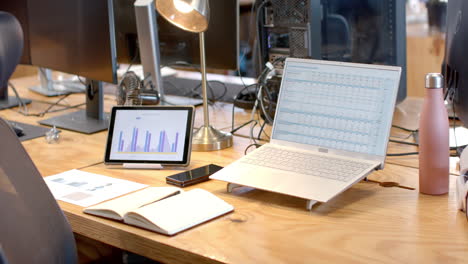 Ein-Modernes-Business-Büro-Setup-Präsentiert-Einen-Laptop-Mit-Datendiagrammen-Auf-Dem-Bildschirm