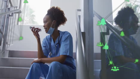 Animation-Eines-Netzwerks-Von-Verbindungen-über-Einer-Afroamerikanischen-Ärztin,-Die-Auf-Einem-Smartphone-Spricht