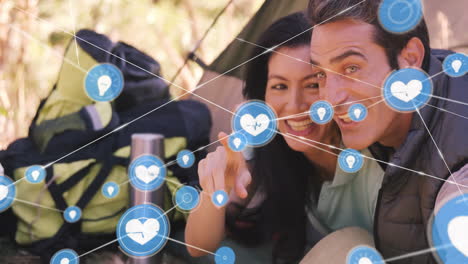 Animation-of-network-of-connections-with-icons-over-caucasian-couple-embracing-in-tent