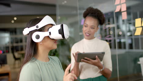 Biracial-woman-tries-on-VR-headset-in-an-office-business-setting,-with-copy-space
