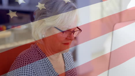 Animation-Der-US-Flagge-über-Einer-älteren-Kaukasischen-Frau-Mit-Laptop