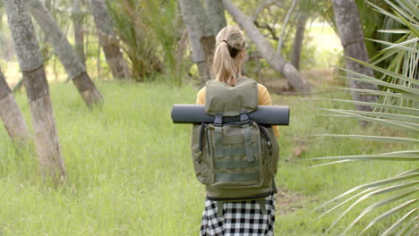Young-Caucasian-woman-with-a-backpack-is-ready-for-a-hike-in-the-woods-with-copy-space