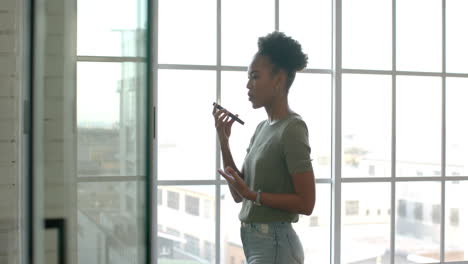 Young-African-American-businesswoman-stands-by-a-window-in-a-bright-room,-with-copy-space