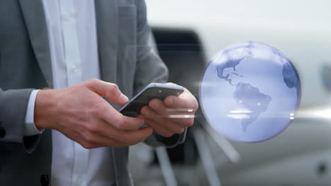 Animation-of-spinning-globe-over-caucasian-businessman-using-smartphone-at-airport