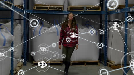 Animation-of-network-of-connections-over-caucasian-female-worker-walking-in-warehouse