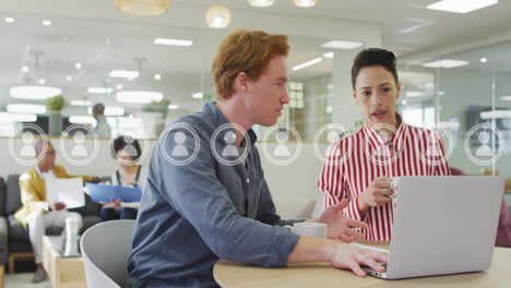 Animation-of-user-icons-over-caucasian-colleagues-talking-in-office