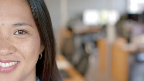 Close-up-of-an-Asian-business-woman-smiling-in-an-office-environment-with-copy-space