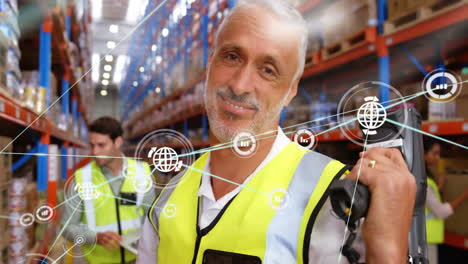 Animation-of-network-of-connections-with-icons-over-caucasian-male-workers-working-in-warehouse