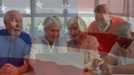 Animation-of-flag-of-usa-over-diverse-senior-people-using-laptop
