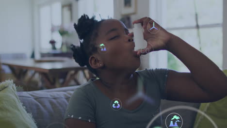 Animation-of-eco-icons-and-data-processing-over-african-american-girl-using-inhaler-at-home