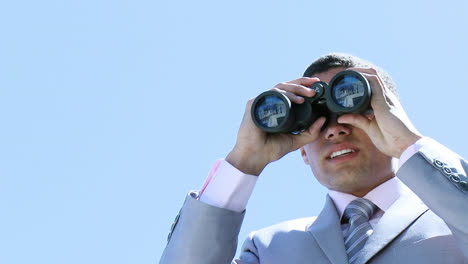 Young-businessman-looking-through-binoculars