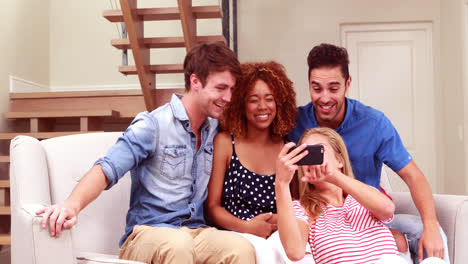 Smiling-friends-taking-selfies-with-smartphone
